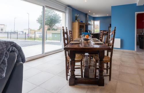 une salle à manger avec une table et des chaises en bois dans l'établissement La proue - appt avec terrasse à moins de 100m de la plage, à Saint-Côme-de-Fresné