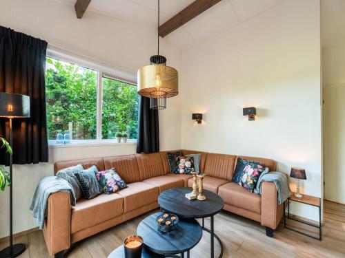 uma sala de estar com um sofá e uma mesa em Cosy holiday home in the countryside em Hellendoorn