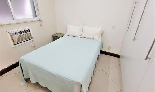 Habitación pequeña con cama y ventana en Ótimo quarto e sala em área nobre do Leblon, en Río de Janeiro