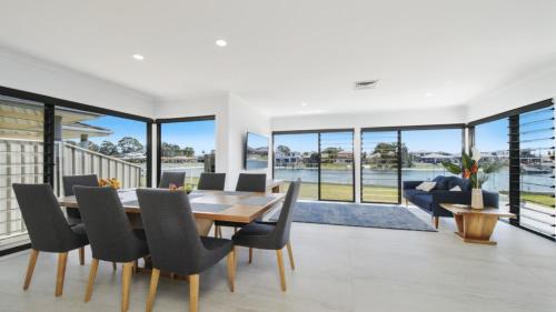 a dining room with a table and chairs at FLOATING ON THE CANALS - 80 COMMODORE CRES in Port Macquarie