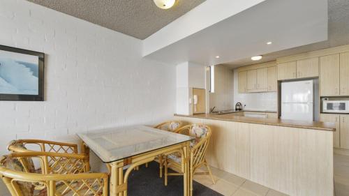 a kitchen with a table and chairs and a counter at 15 Beachpark Apartments in Port Macquarie