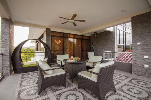 a patio with chairs and a table and a ceiling fan at Bella Villa Coron in Coron