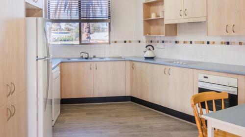 a kitchen with a sink and a refrigerator at Perfectly Positioned Beachfront Apartment - Unit 6 in Port Macquarie