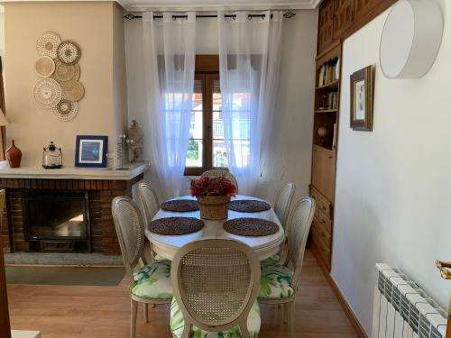 uma sala de jantar com mesa e cadeiras em El balcón de Araceli em Cercedilla