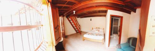 a small room with a bed and a staircase at La Casa de las Flores Hostal in Jardin