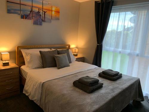 a bedroom with a bed with two towels on it at Modern Cosy Warm Home With Free Parking in Chelmsford