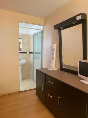 a bathroom with a vanity with a mirror and a sink at Hotel Sierra Inn in Xicotepec de Juárez