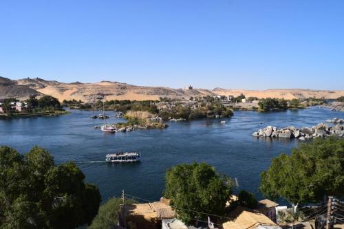 a river with boats in the middle of a town at Go Inn Backpackers in Aswan