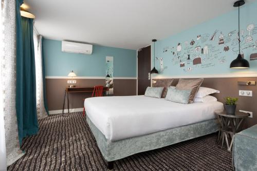 sypialnia z dużym łóżkiem i niebieską ścianą w obiekcie Hôtel des 3 Poussins w Paryżu