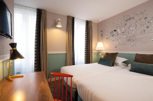 Ein Bett oder Betten in einem Zimmer der Unterkunft Hôtel des 3 Poussins