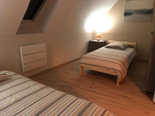 ein Schlafzimmer mit 2 Betten und einer Lampe an der Wand in der Unterkunft l industriel in Hem-Lenglet