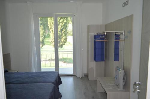1 dormitorio con 1 cama y puerta corredera de cristal en La Svolta Holidays en Malcesine
