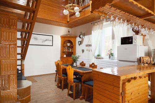 a kitchen with a wooden table and a refrigerator at Zemplén Gyöngye Vendégház in Erdőhorváti