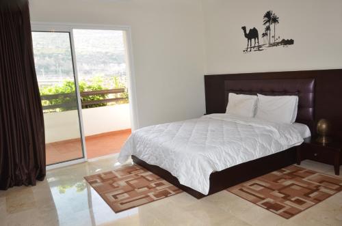 1 dormitorio con cama grande y ventana grande en Lovely Marina Flat, en Agadir