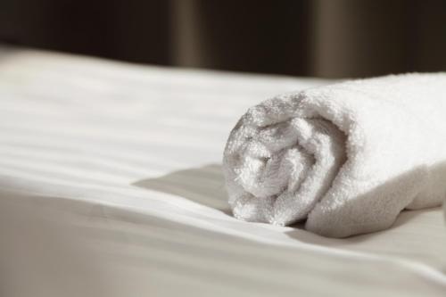a hand with a towel on a bed at Zemplén Gyöngye Vendégház in Erdőhorváti