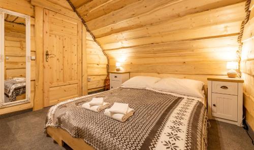 a bedroom with a bed in a log cabin at Domki na Kamiennej Laworcie 789410422 in Ustrzyki Dolne