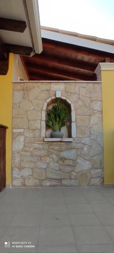 a stone wall with a plant in a window at Andri House in Marathias