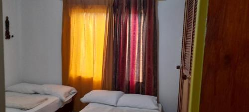 a room with two beds and a window at Rosita 2 in Jardin