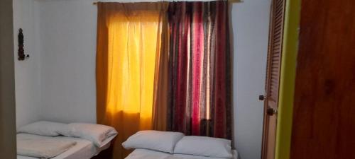a room with two beds and a colorful curtain at Rosita 2 in Jardin