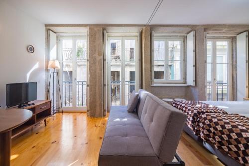 a living room with a couch and a bed and windows at YOUROPO - The Tower in Porto