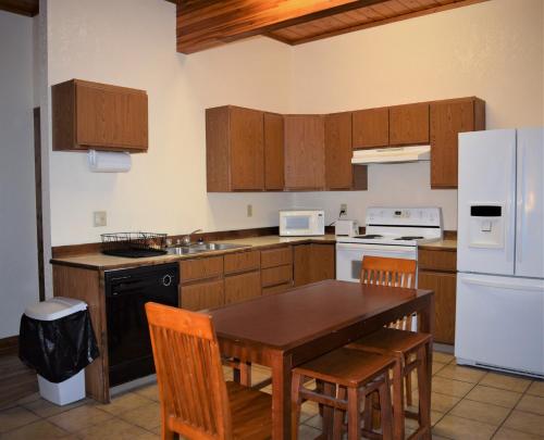 a kitchen with wooden cabinets and a table and chairs at Bison Trail Chateau Livingston, Montana in Livingston
