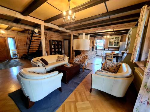 a large living room with two couches and a couch at Dworek Ogrodniki, całoroczny dom na wyłączność, basen, sauna, las, staw rybny, altana grillowa, ognisko, pianino, kominek, piec chlebowy, duża ogrodzona posesja in Tuczna