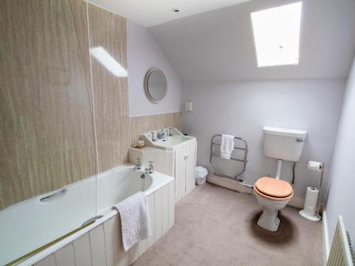 a bathroom with a toilet and a tub and a sink at Rottal Farmhouse in Millton of Clova