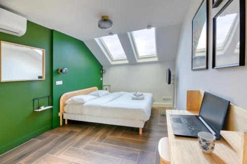 Un dormitorio con una cama y un escritorio con una computadora portátil. en Five to Sete, en Sète