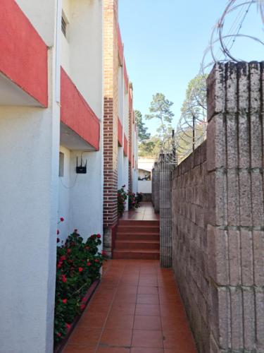 a hallway of a building with a brick wall at Hotel Kasa Kamelot Las Rosas in Quetzaltenango