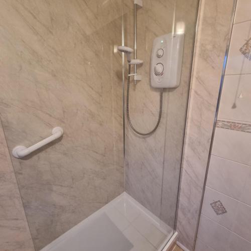 a bathroom with a shower with a glass door at PREMIER - Whifflet Apartment in Coatbridge