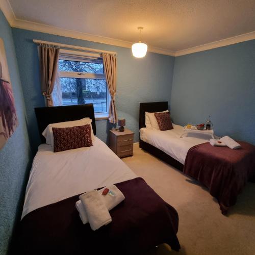a bedroom with two beds and a window at PREMIER - Whifflet Apartment in Coatbridge