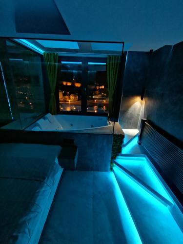 a balcony with a tub in a room with blue lights at PentLux - SPA Penthouse in the heart of Skopje in Skopje