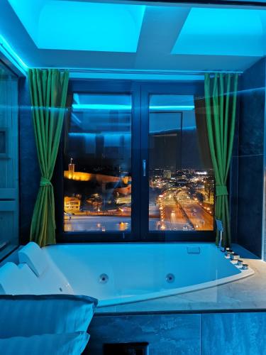a room with a tub in front of a window at PentLux - SPA Penthouse in the heart of Skopje in Skopje