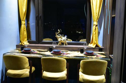 a table with chairs and a table with wine glasses at PentLux - SPA Penthouse in the heart of Skopje in Skopje