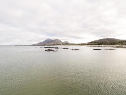 a large body of water with a mountain in the background at At the Crossroads in Louisburgh