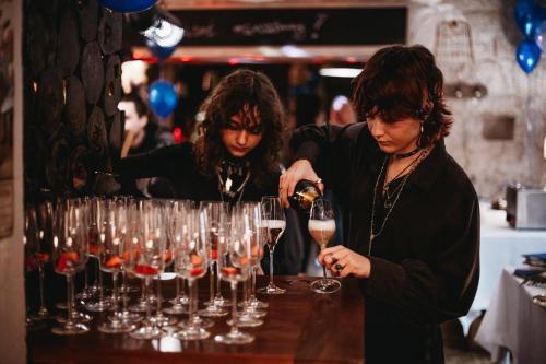two women standing at a bar with wine glasses at Apartments Rose Garden in Děčín