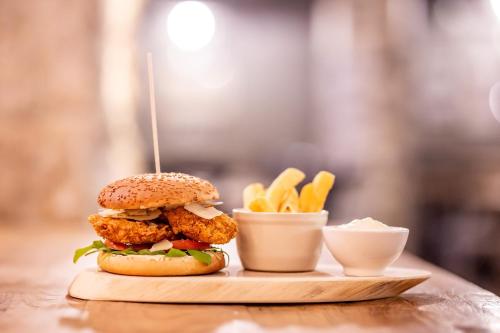 a chicken sandwich and french fries on a table at Apartments Rose Garden in Děčín