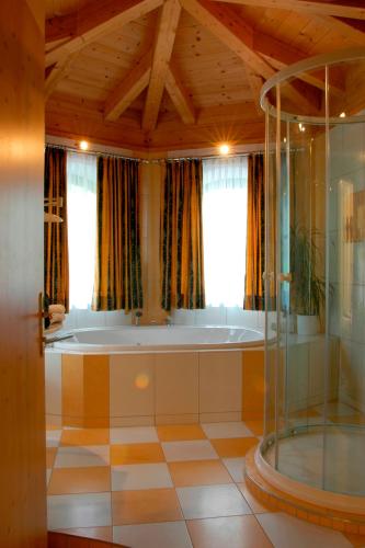 a bath tub in a room with a window at Golf- und Sporthotel Moarhof in Walchsee