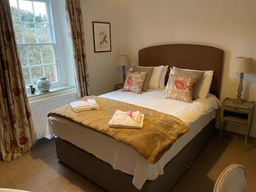 a bedroom with a large bed with two towels on it at Pear Cottage - Priorwood Garden in Melrose