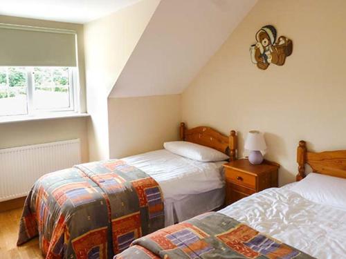 a attic bedroom with two beds and a window at Lovers' Lodge in Kilkenny