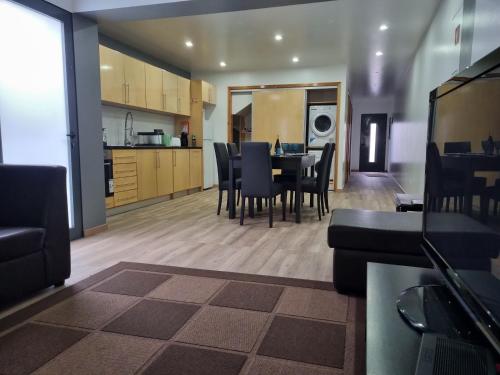 a kitchen and dining room with a table and chairs at Casa do João Bento in Água de Alto