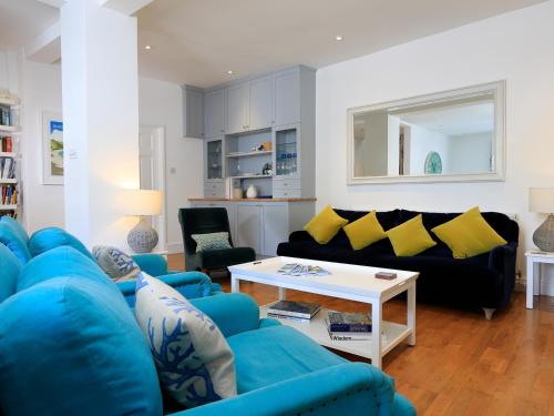 a living room with a blue couch and yellow pillows at Armorel House in Dartmouth