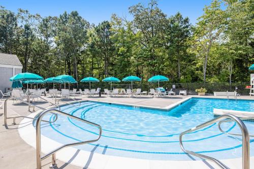 a swimming pool with chairs and umbrellas at Sea Colony --- 508 Brandywine house in Bethany Beach