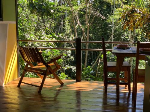 einen Schaukelstuhl und einen Tisch auf einer Veranda in der Unterkunft Pequeño Paraiso 2 in Punta Uva