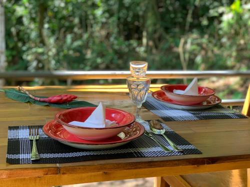 a table with two red plates and a glass on it at Pequeño Paraiso 2 in Punta Uva