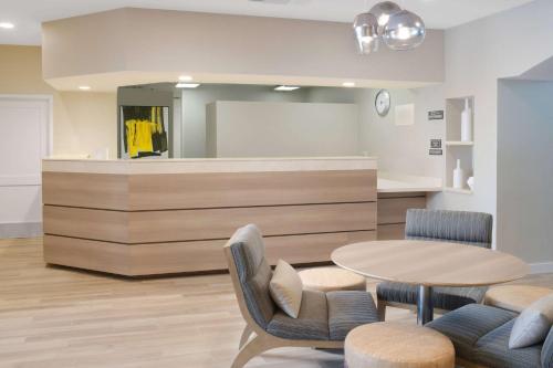 a waiting room with a table and chairs at Sonesta ES Suites Fort Worth Fossil Creek in Fort Worth