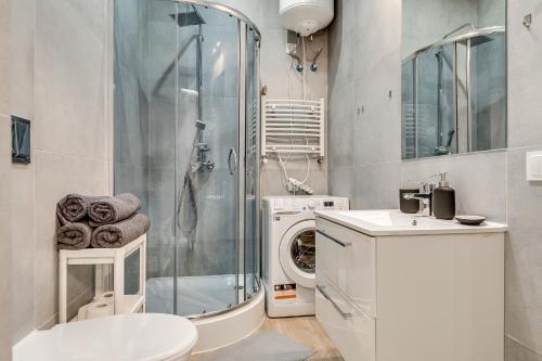 a bathroom with a shower and a washing machine at Central Platinum Apartments 7 in Rybnik