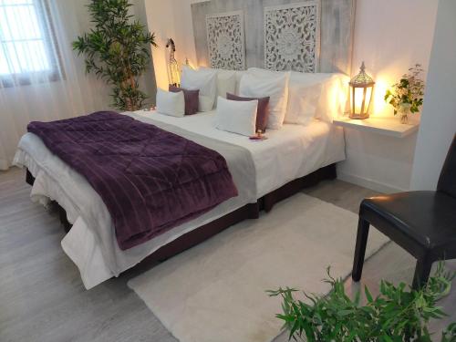 a bedroom with a large bed with white sheets and pillows at Alojamiento PLAZA CASCO HISTORICO in Icod de los Vinos