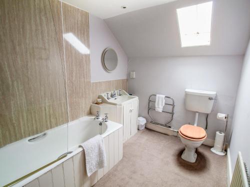 a bathroom with a toilet and a tub and a sink at Rottal Bothy in Millton of Clova