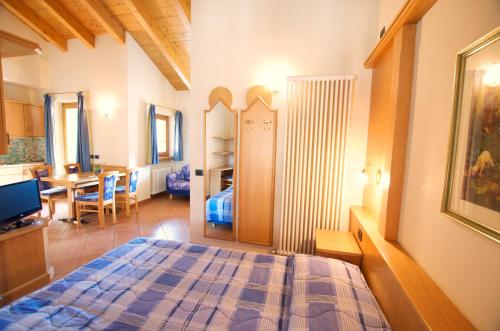 a bedroom with a bed and a dining room at Miky House - Appartamenti Abar in Livigno